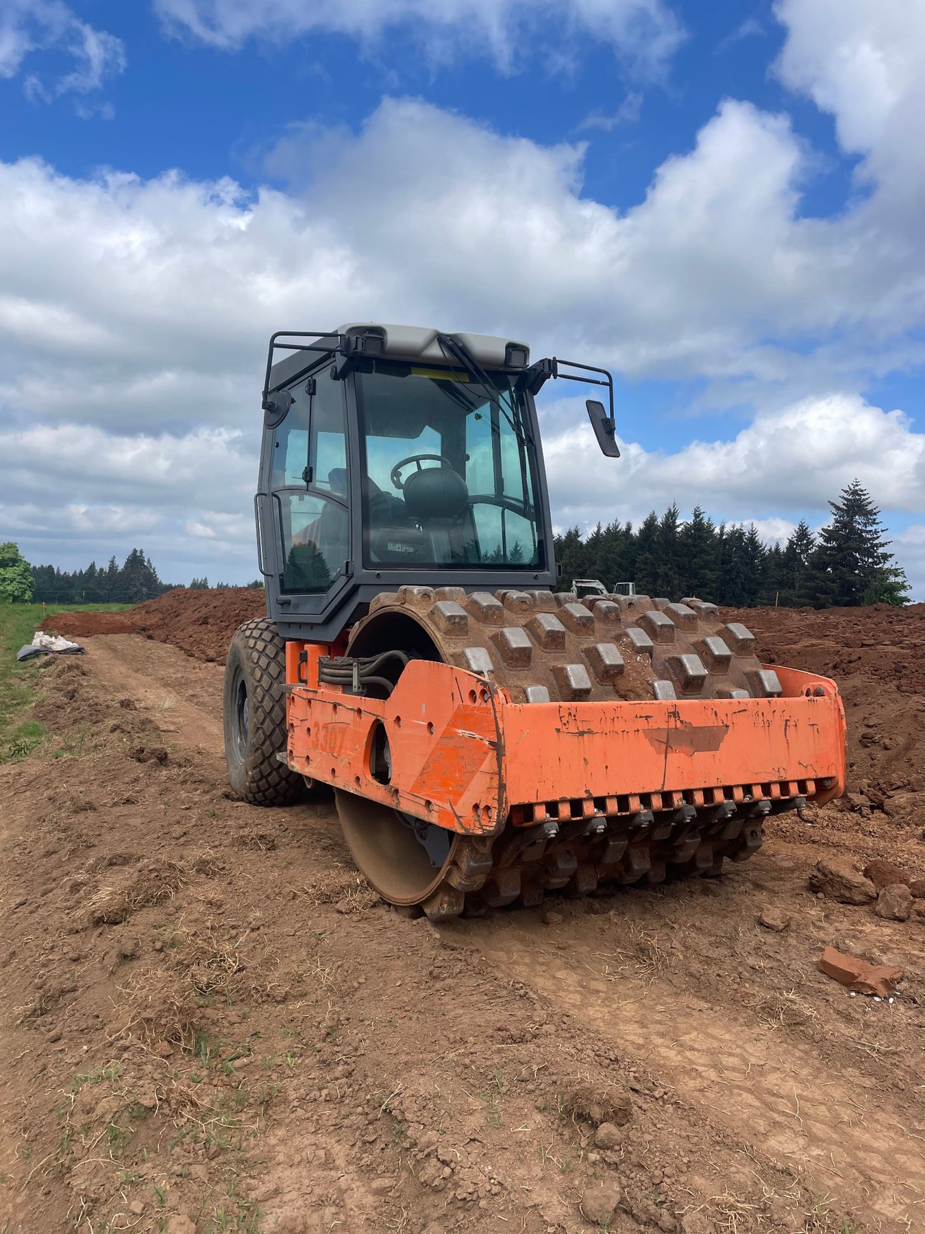 Orange Hamm compactor working at a jobsite
